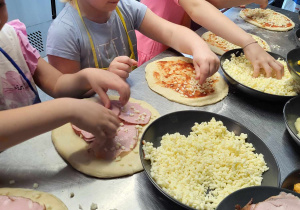 Dzieci robią pizzę.