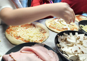 Dzieci wybierają składniki na pizzę.