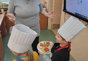 Dzieci częstują kanapkami pracowników szkoły i przedszkola