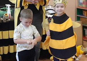 Dzieci uczestniczą w warsztatach pszczelarskich.