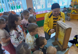 Dzieci uczestniczą w warsztatach pszczelarskich.