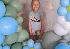 Julka pozuje wśród dekoracji z balonów