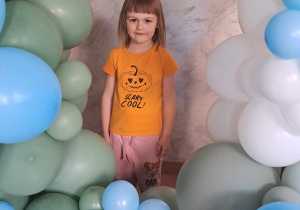Zuzia pozuje wśród dekoracji z balonów