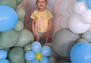 Maja pozuje wśród dekoracji z balonów