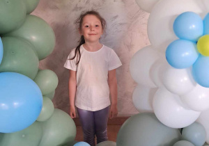Amelia pozuje wśród dekoracji z balonów