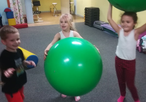 Dzieci w zabawie wykorzystują duże gumowe piłki