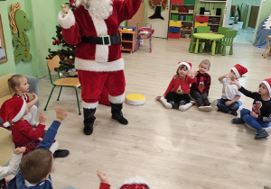 Święty Mikołaj bawi się z dziećmi.