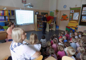 Dzieci uważnie oglądają prezentację na tablicy multimedialnej