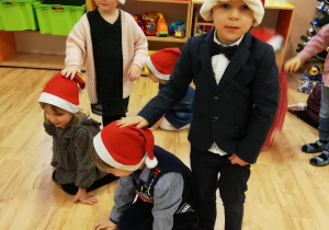 Czworo dzieci bawi się w renifery i mikołaje - Mikołaje głaszczą swoje renifery