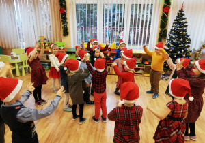 Dzieci tańczą w kole do świątecznej muzyki