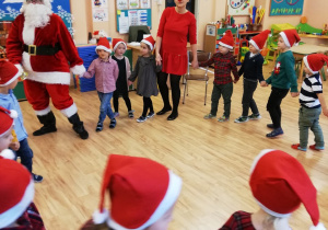 Dzieci tańczą z Mikołajem i reniferem