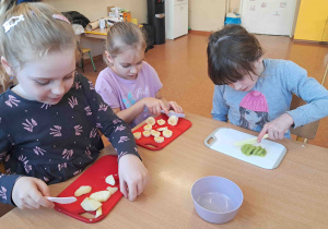 Dzieci kroją owoce i warzywa na koktajl