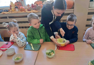 Dzieci kroją owoce i warzywa na koktajl