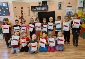 Dzieci trzymają w rękach wyklejone z bibuły flagi Polski