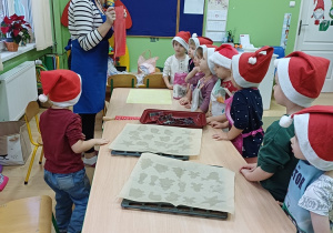 Nauczycielka prezentuje potrzebne rzeczy do wykonania pierników