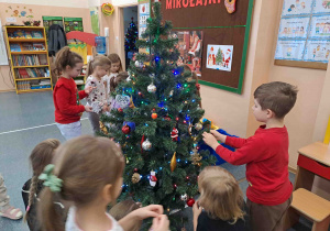 Dzieci ubierają choinkę