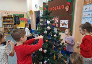 Dzieci ubierają choinkę