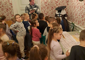 Dzieci zwiedzają muzeum i oglądają stroje dam dworu