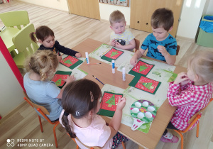 Dzieci dekorują karty świąteczne przy pierwszym stoliku