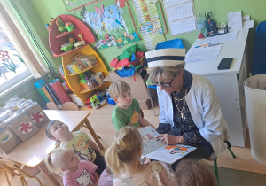 Pielęgniarka czyta dzieciom bajkę