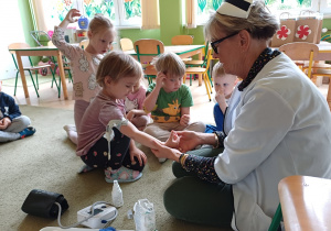 Pielęgniarka przedstawia dzieciom etapy pobierania krwi