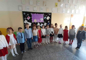 Dzieci biorące udział w konkursie stoją w półkolu w oczekiwaniu na wyniki