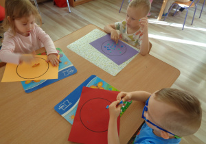 Dzieci wyklejają plasteliną pracę ,,Kropki w kropce".