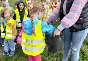 Dzieci sprzątają teren zielony