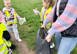 Dzieci podczas akcji porządkują teren wokół Szkoły Podstawowej nr 1
