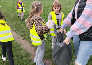 Dzieci podczas akcji porządkują teren wokół Szkoły Podstawowej nr 1
