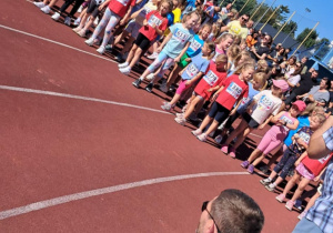 Dzieci na stadionie miejskim biorą udział w biegu