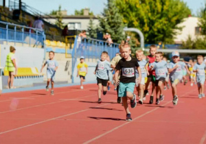 Dzieci na stadionie miejskim biorą udział w biegu