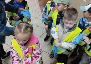 Dzieci zakładają rękawiczki jednorazowe na ręce