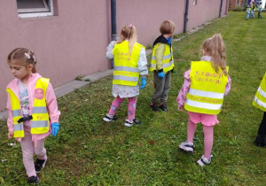 Dzieci spacerują i zbierają śmieci do worka