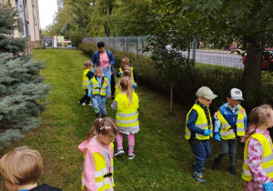Dzieci spacerują i zbierają śmieci do worka