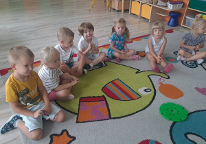 dzieci siedza w kole na dywanie
