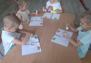 dzieci wykonują karte pracy przy stoliku