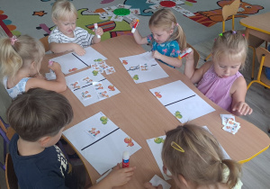 dzieci wykonują karte pracy przy stoliku