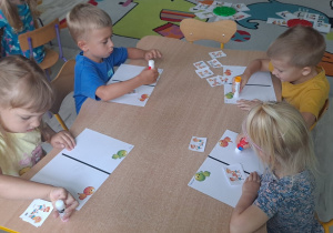 dzieci wykonują karte pracy przy stoliku