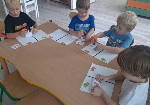 dzieci wykonują karte pracy przy stoliku