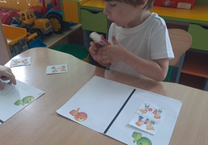 dzieci wykonują karte pracy przy stoliku