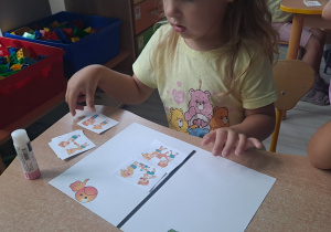 dzieci wykonują karte pracy przy stoliku