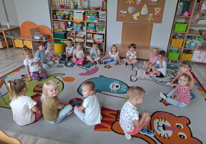 Dzieci siedzą na dywanie