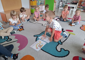 Dzieci siedzą na dywanie