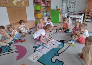 Dzieci siedzą na dywanie