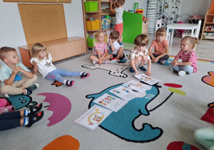 Dzieci siedzą na dywanie