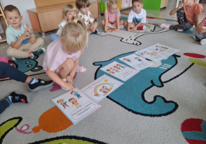 Dzieci siedzą na dywanie