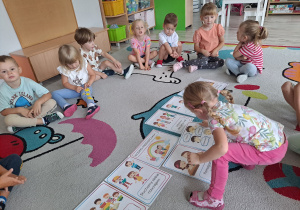 Dzieci siedzą na dywanie