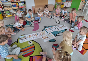 Dzieci siedzą na dywanie