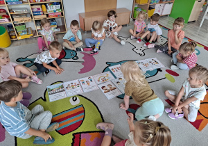 Dzieci siedzą na dywanie